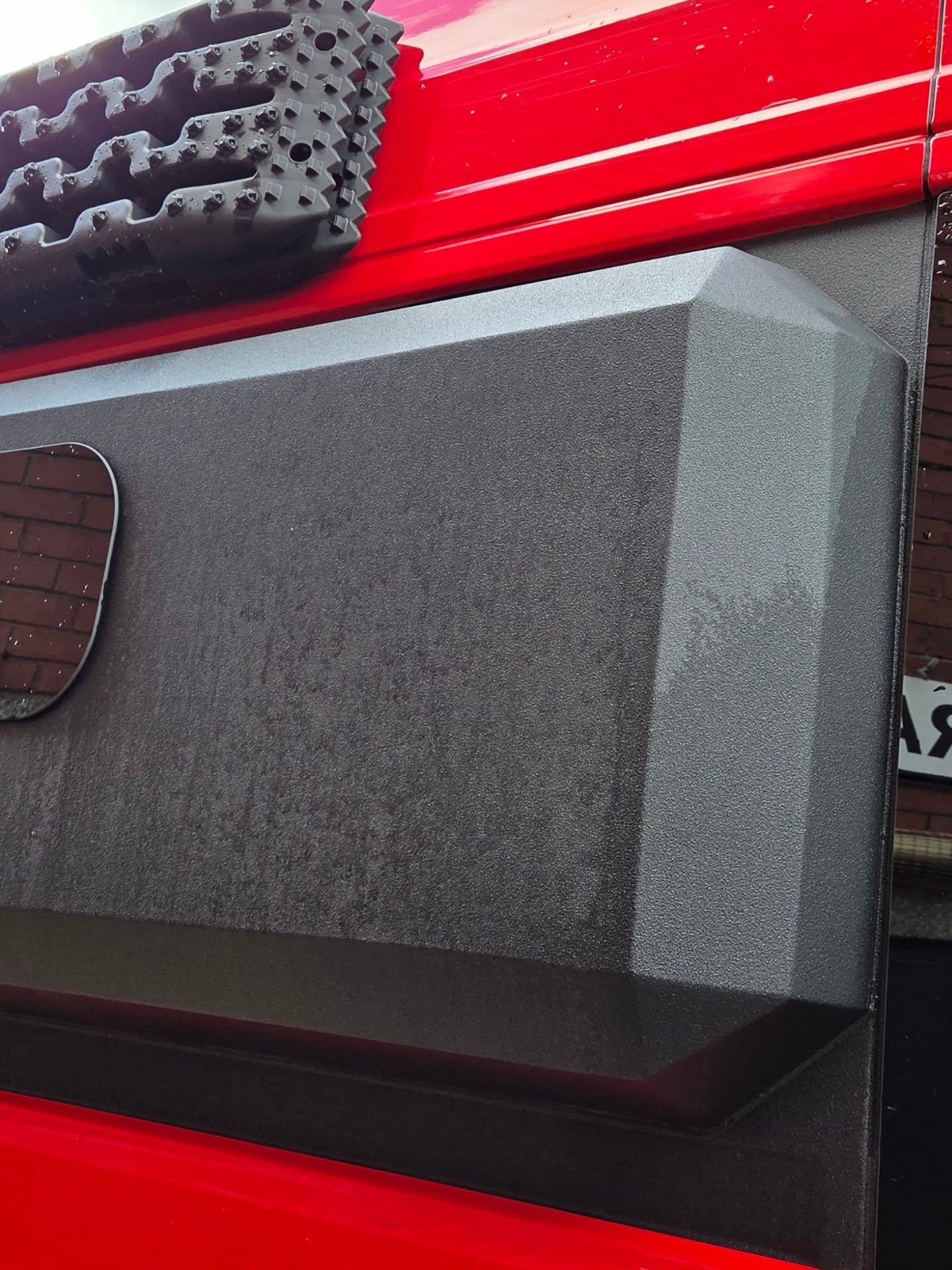 Grey moulded storage pod mounted at roof level on a red VW Crafter camper