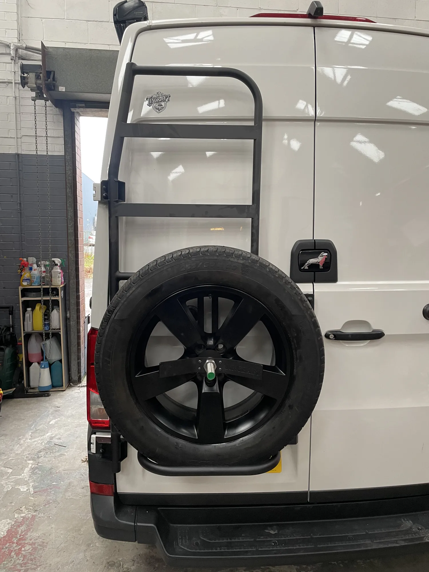 Rear-mounted ladder and spare wheel carrier on a white MAN TGE campervan