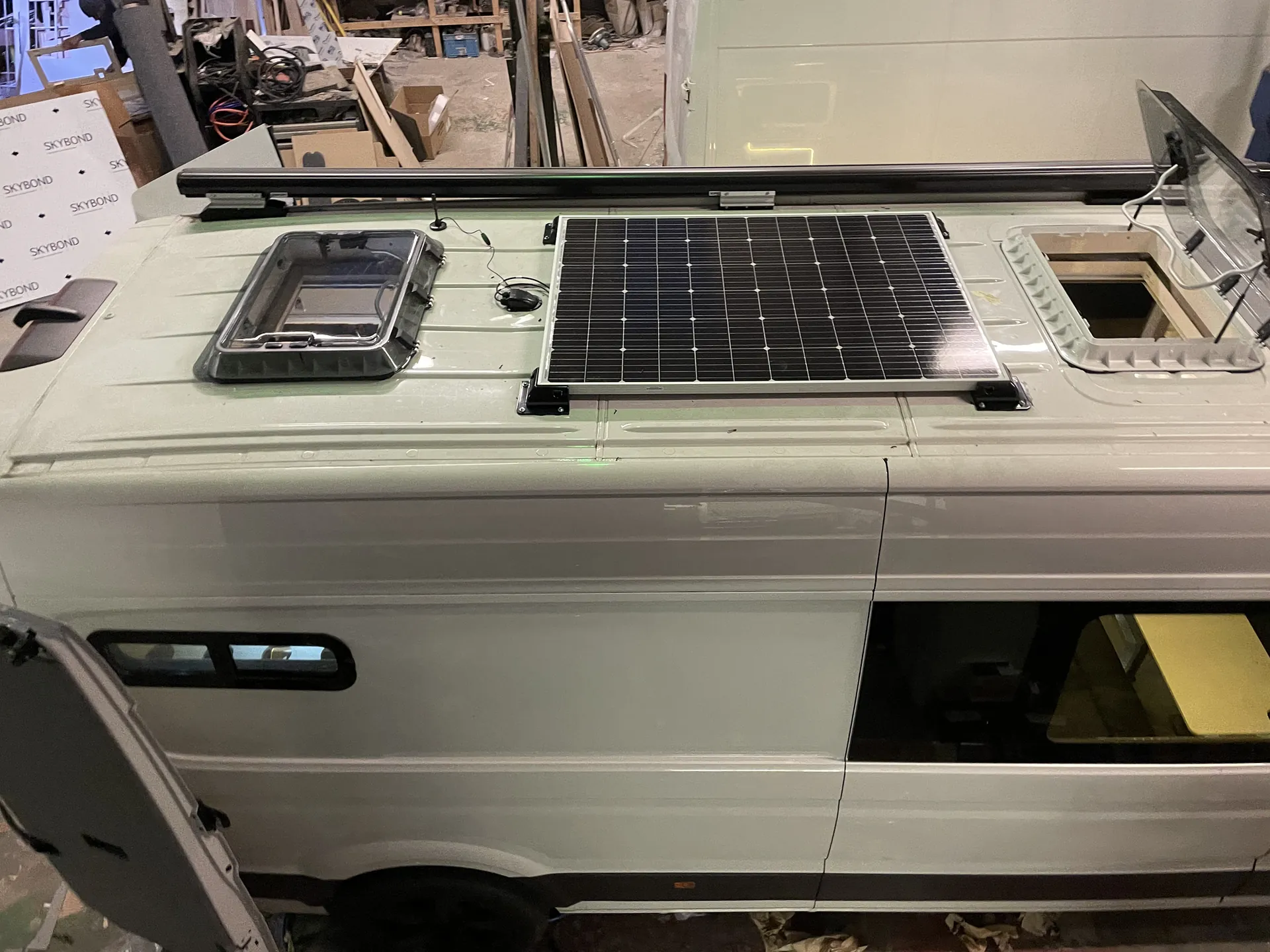 Roof of a MAN TGE conversion showing a solar panel and two rooflights