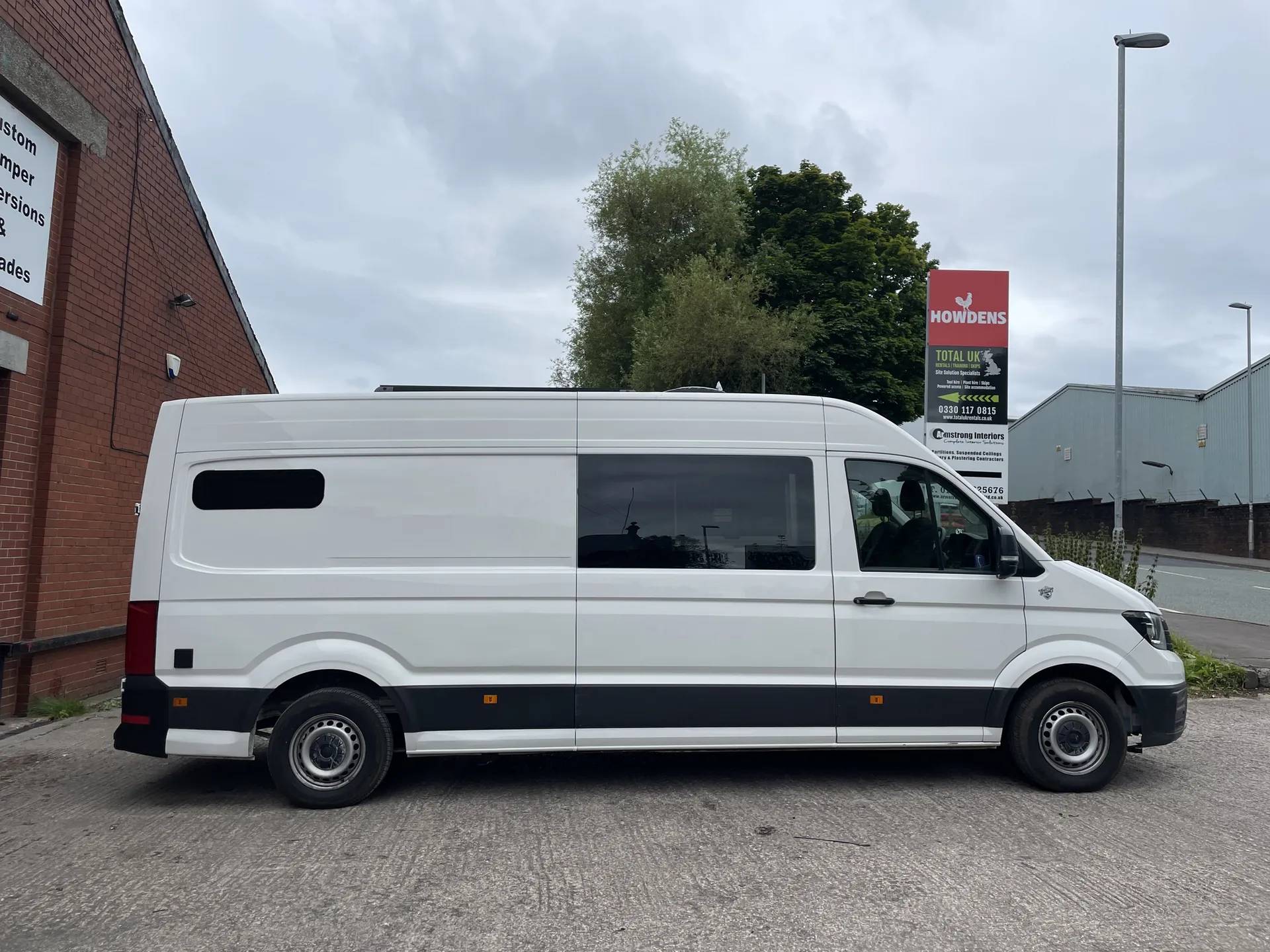 Side profile of a white VW Crafter LWB camper conversion with a side window