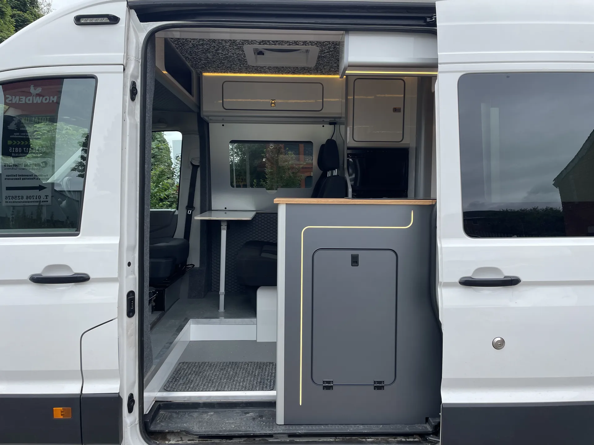 Open side door and step of a white VW Crafter camper conversion