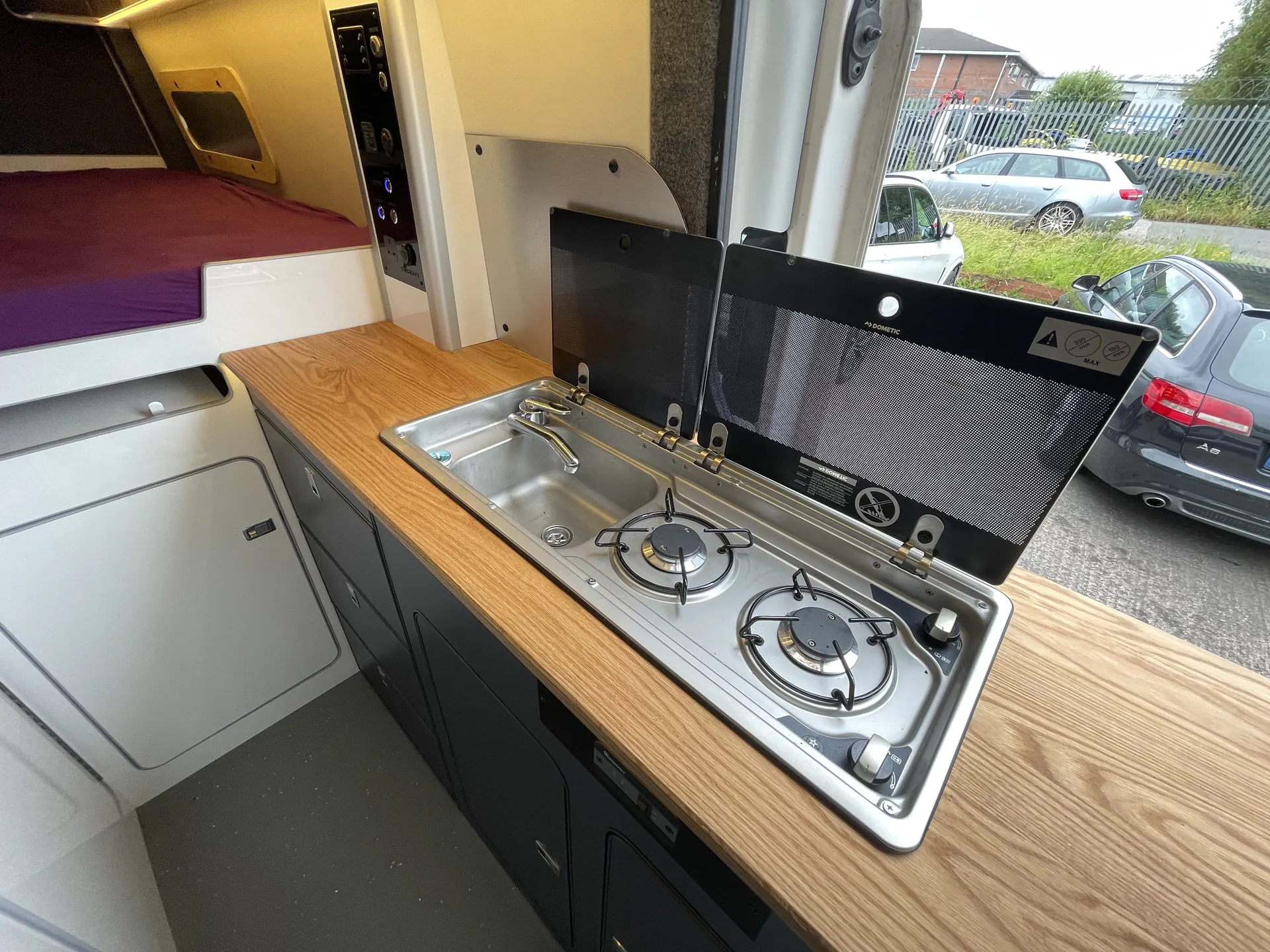 Hob and sink in an oak worktop in a VW Crafter camper galley