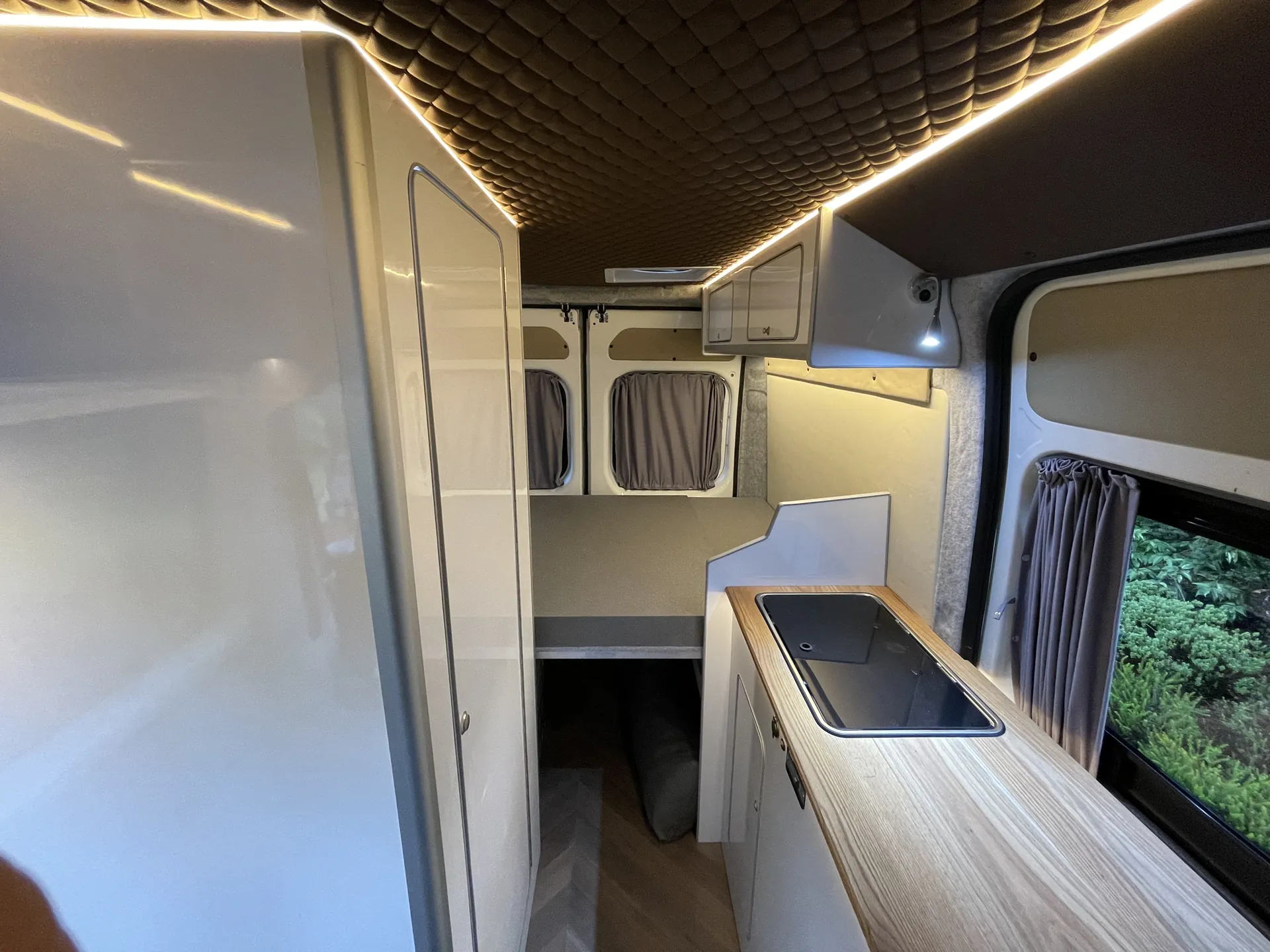 Galley with oak worktop beside a window in a Peugeot Boxer conversion