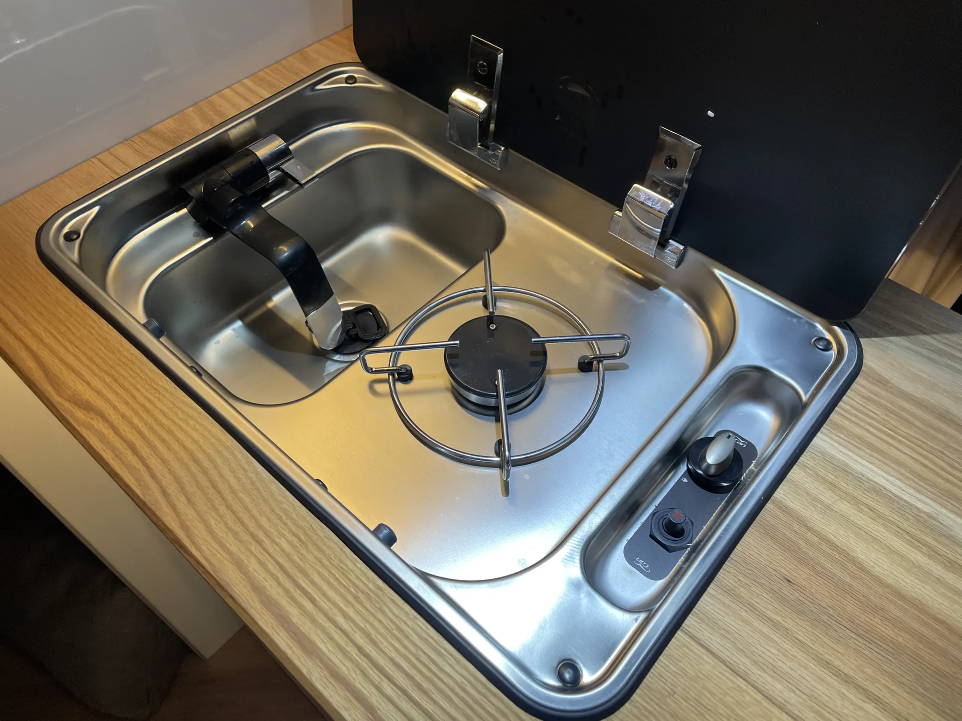 Stainless sink and hob with the lid raised in a Peugeot Boxer camper