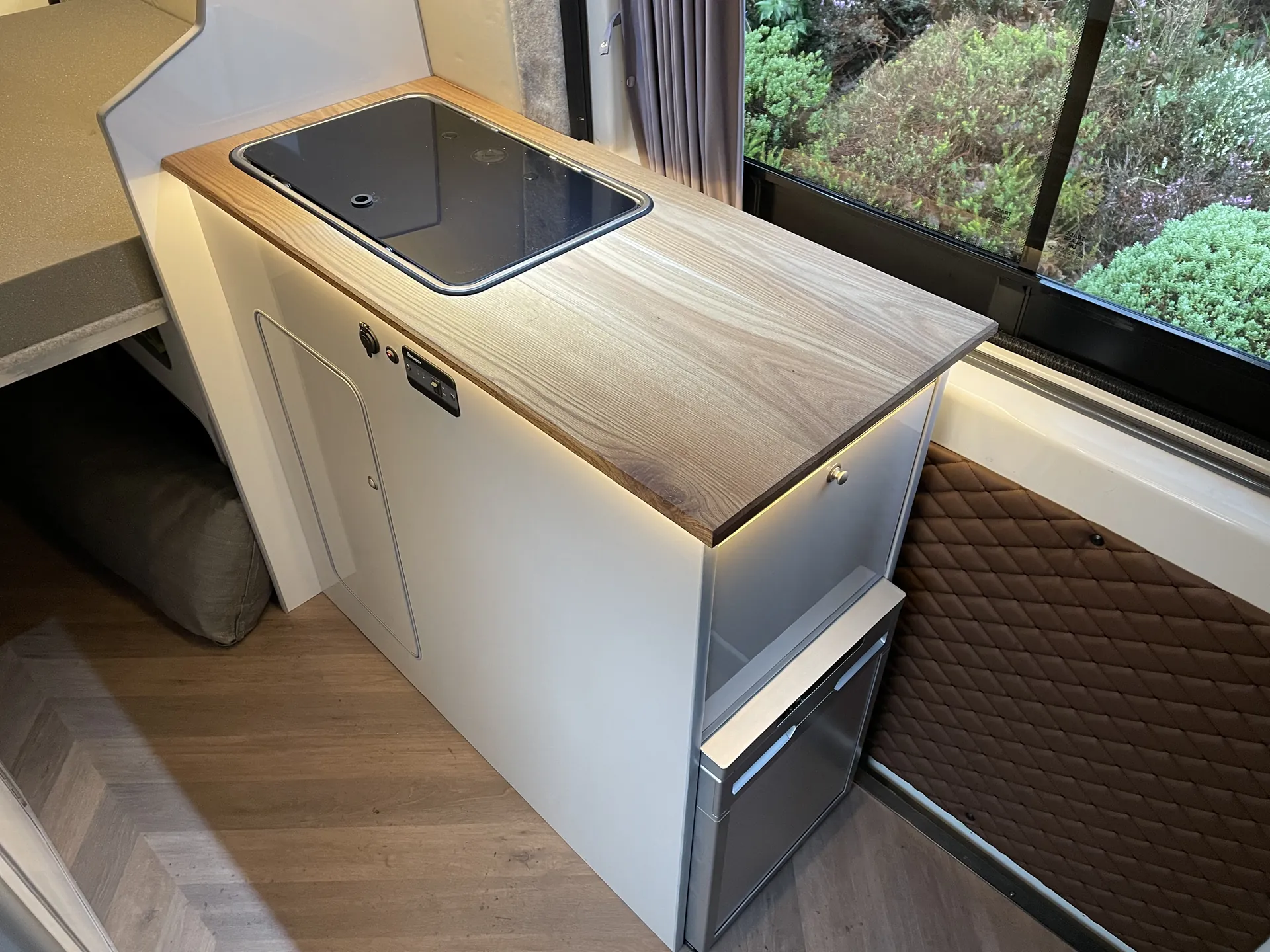 Worktop, hob and drawers above a herringbone vinyl floor in a Boxer camper