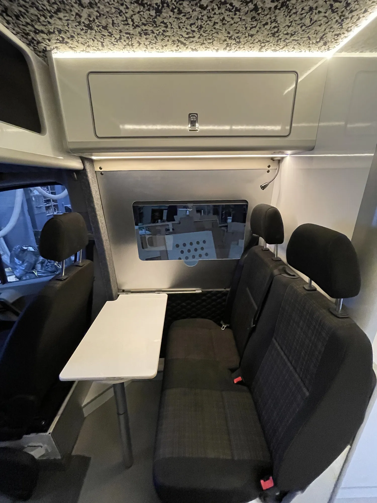 Dinette table set up over the bench seat in a Mercedes Sprinter camper