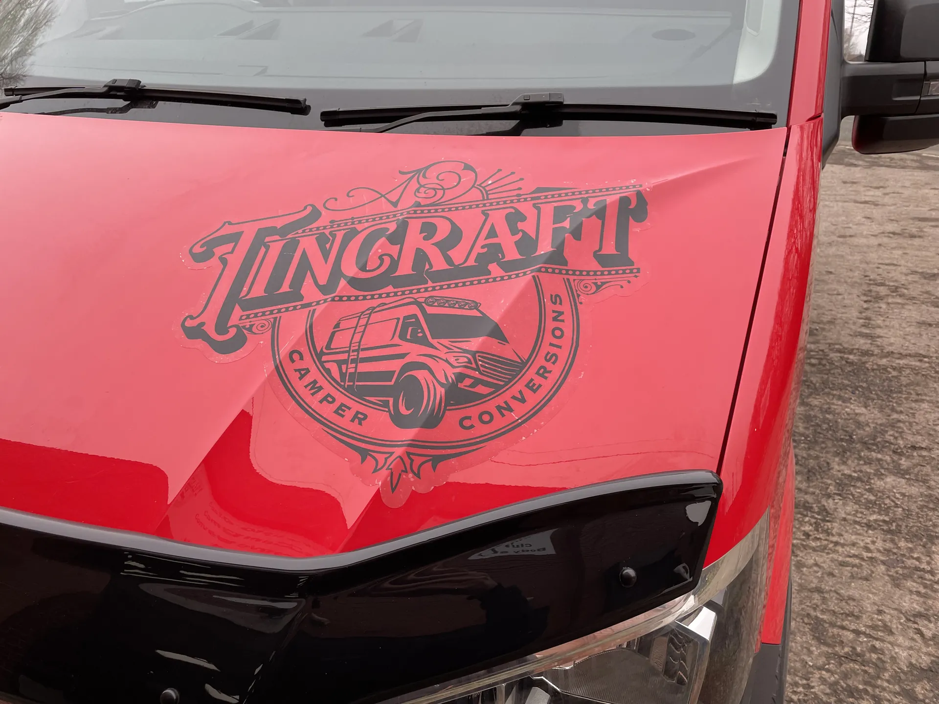 Etched Tincraft artwork on the bonnet of a red VW Crafter campervan
