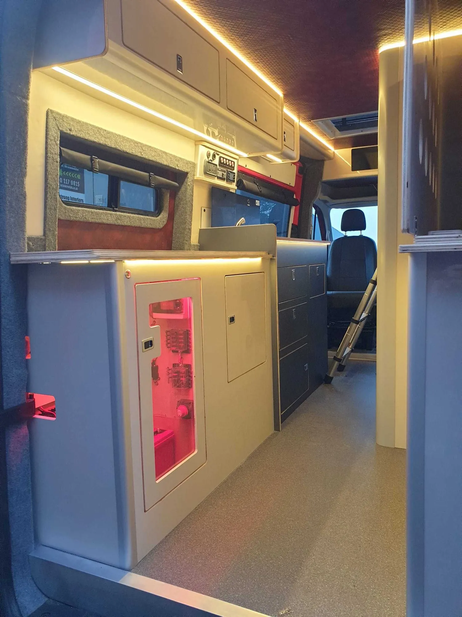 Galley units lit by warm amber LED strip lighting in a VW Crafter camper