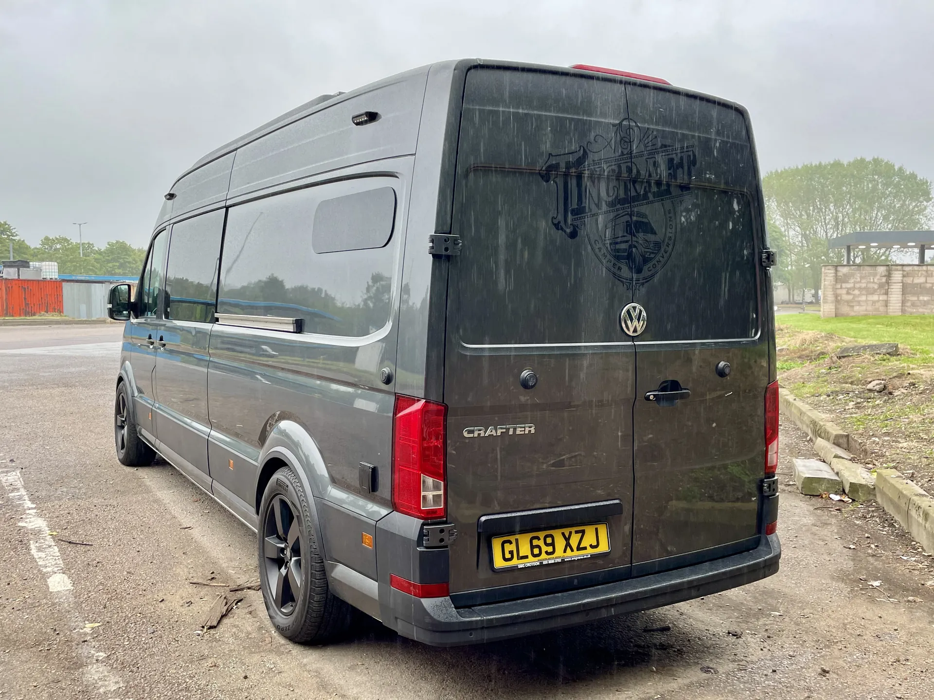 Rear three-quarter view of a grey VW Crafter camper with Tincraft rear graphic
