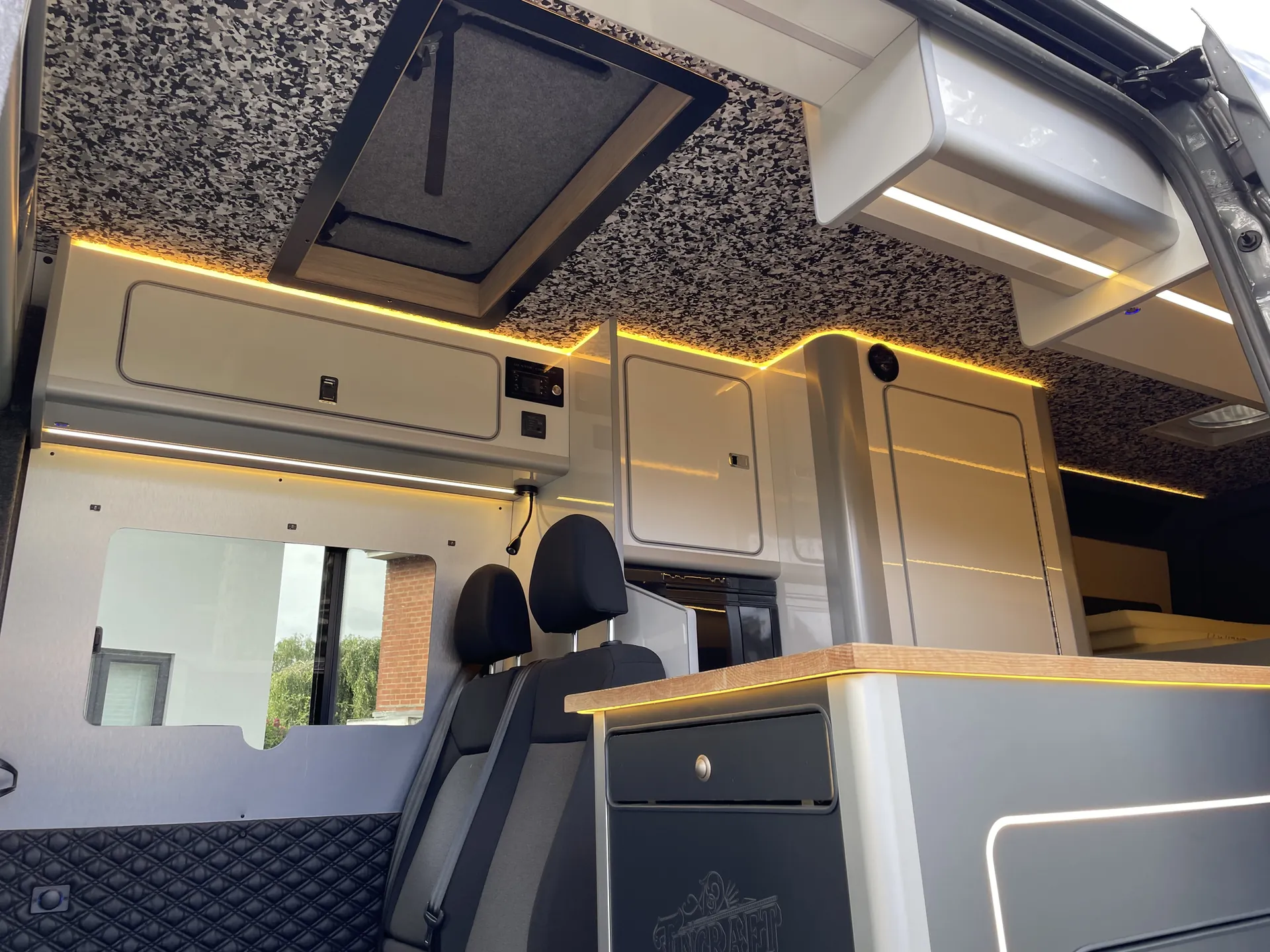 Dinette with oak worktop and LED cove lighting in a grey VW Crafter camper