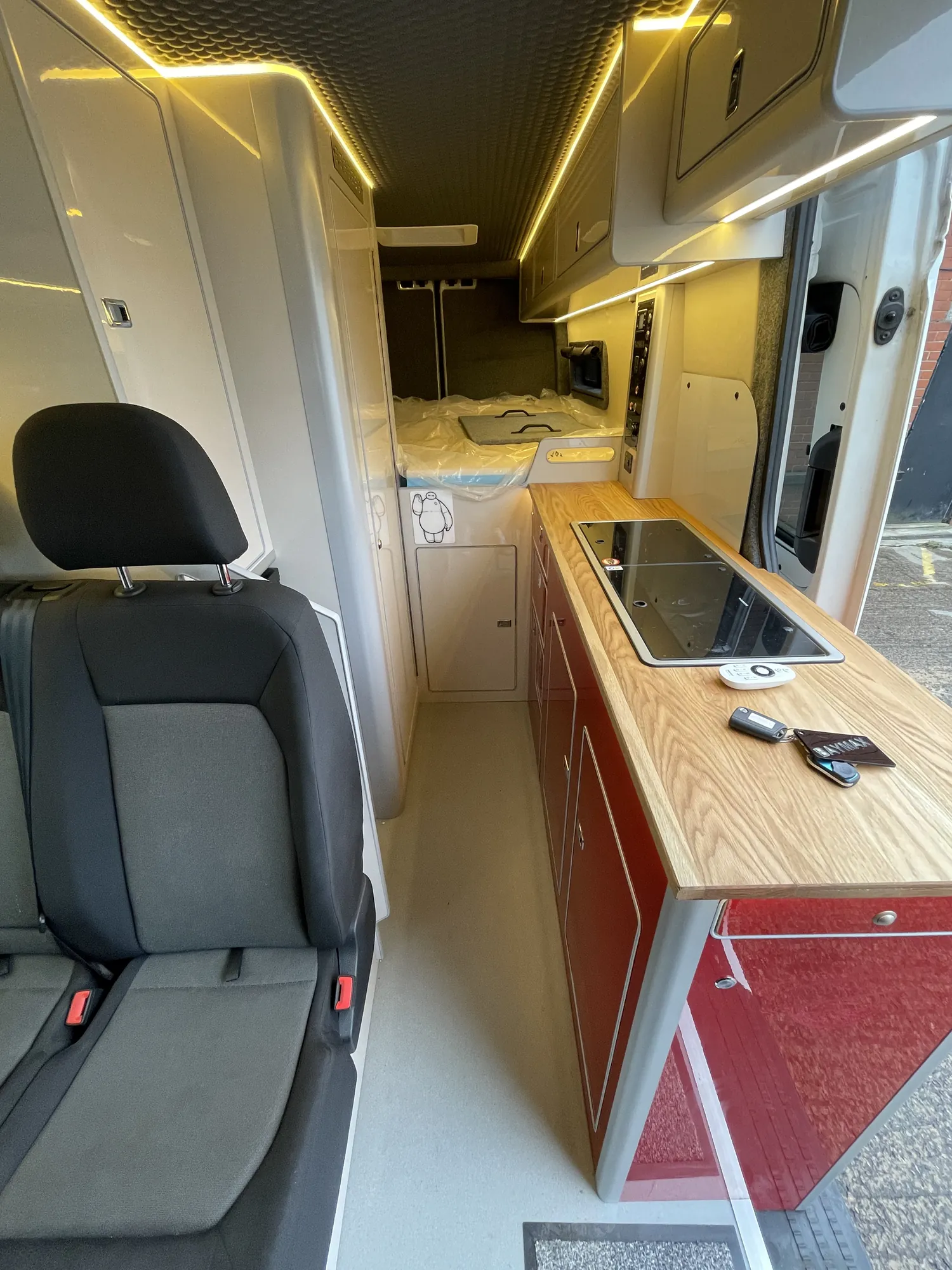 Galley run with warm LED lighting beneath the cupboards in a VW Crafter camper