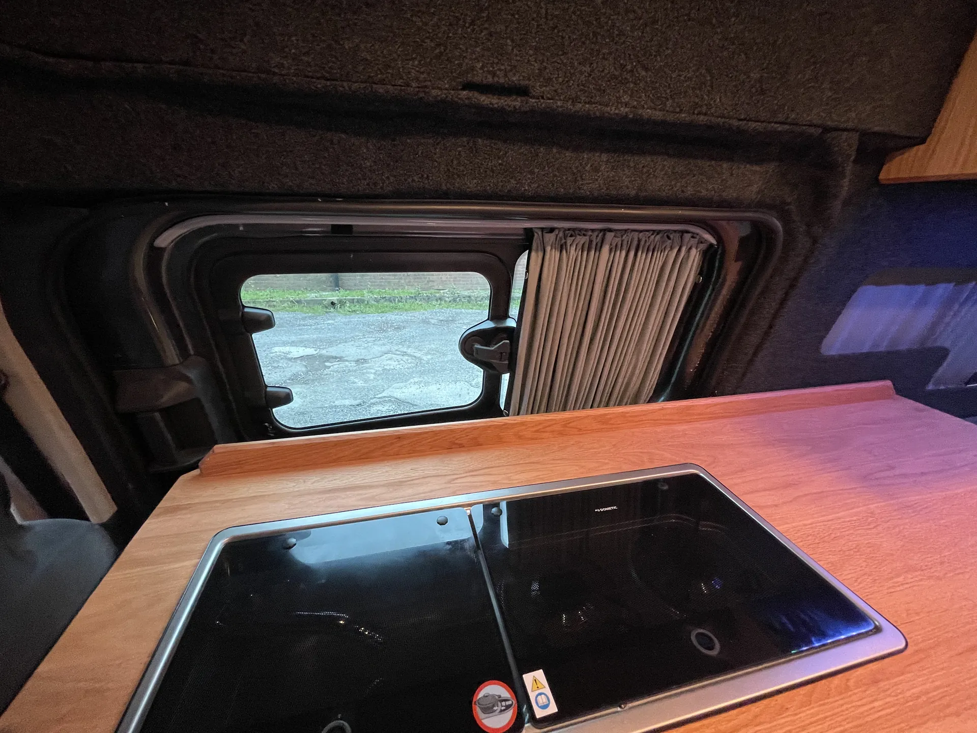 Worktop and hob beside a window in a Ford Transit Custom campervan
