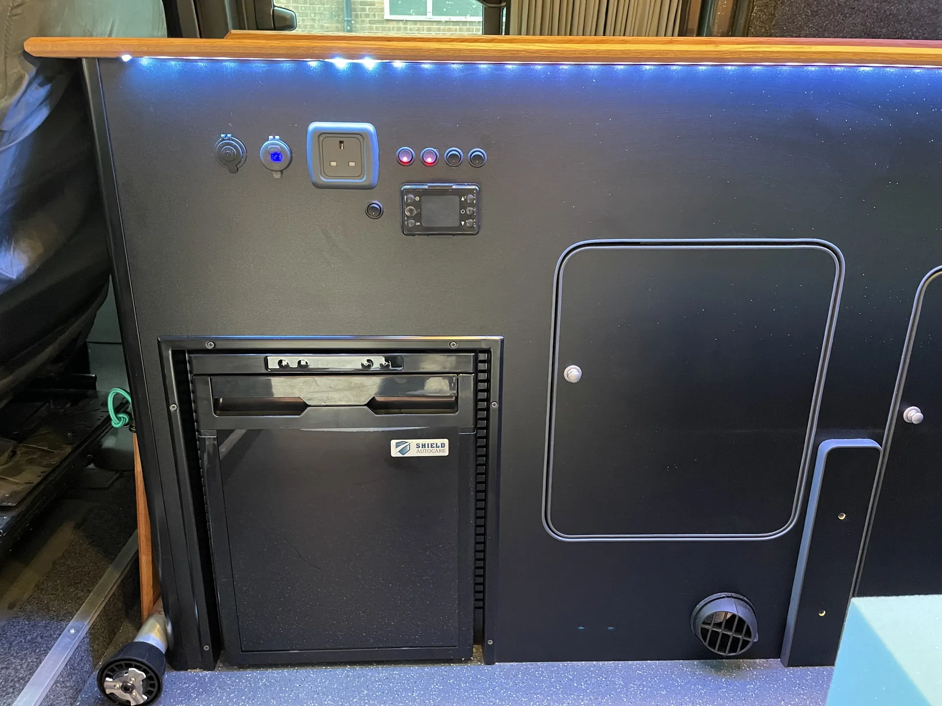 Fridge and control panel built into the units of a Transit Custom camper