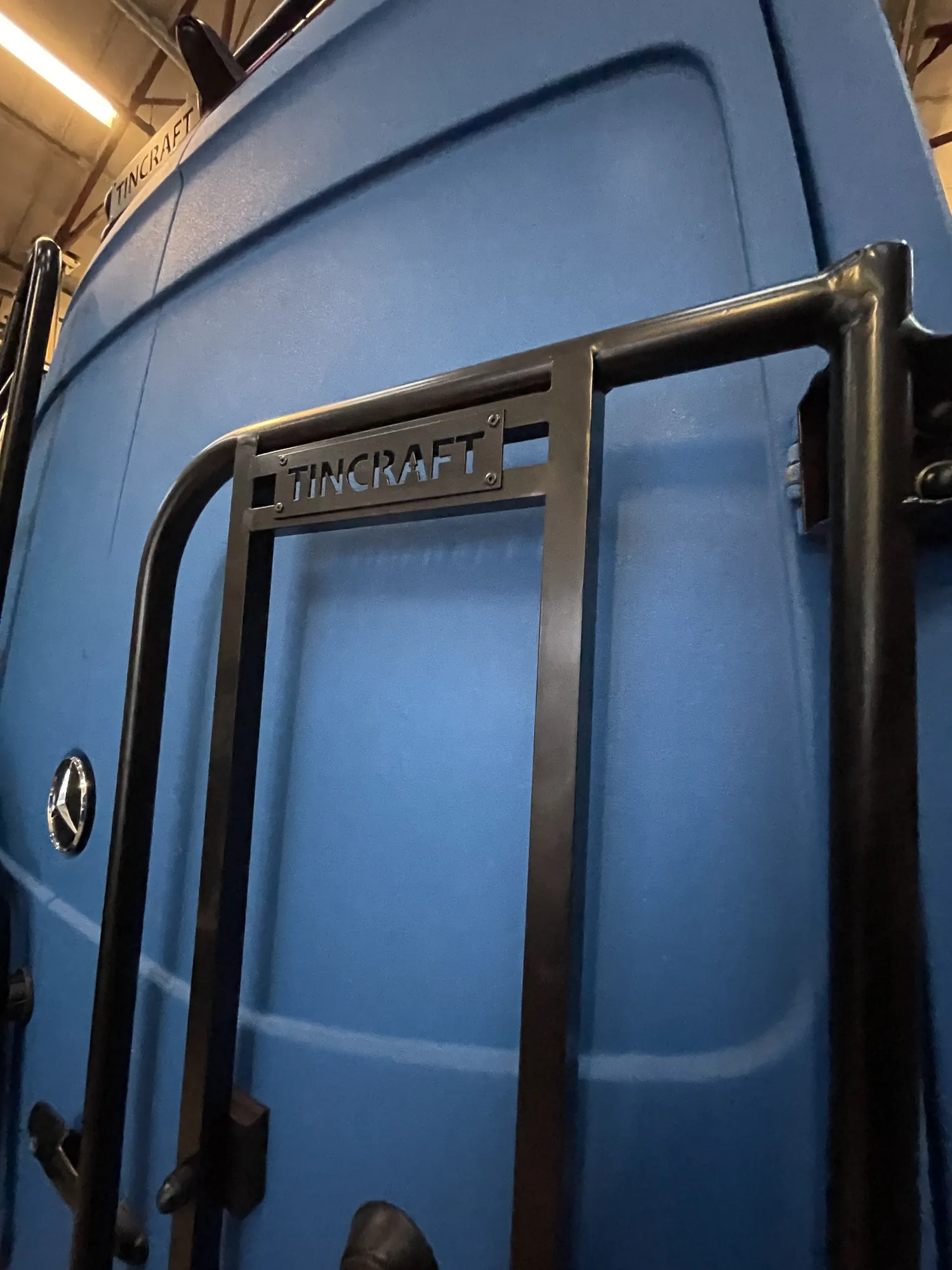Tincraft name engraved into the rear jerry can holder of a blue Sprinter conversion