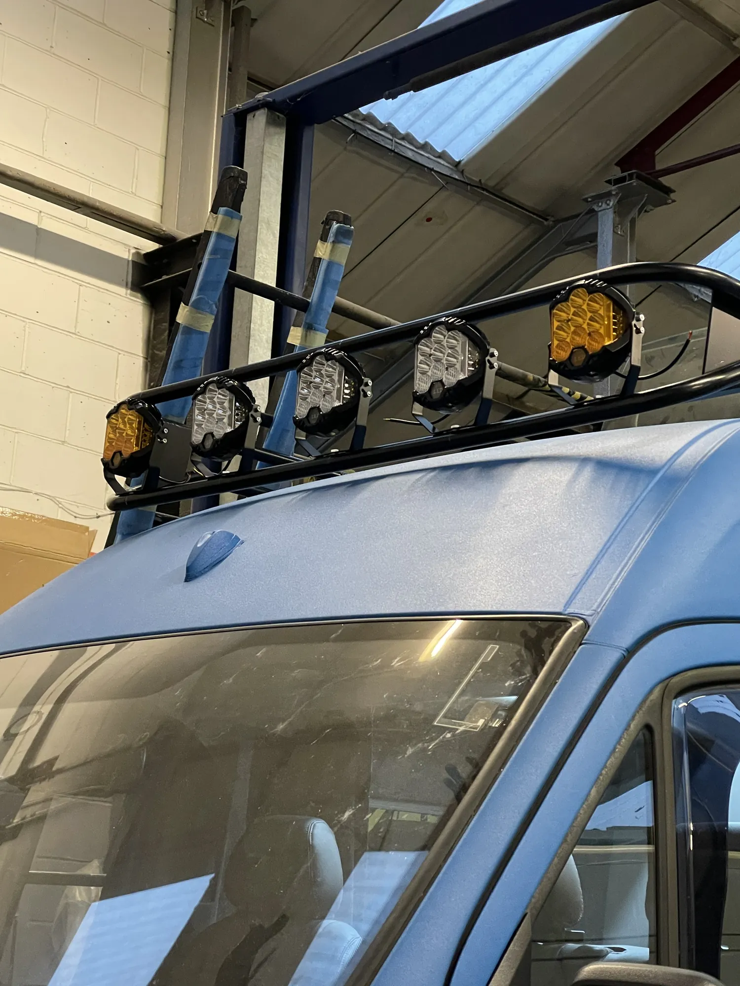 Close-up of LED spotlight pods on the roof rack of a Sprinter camper