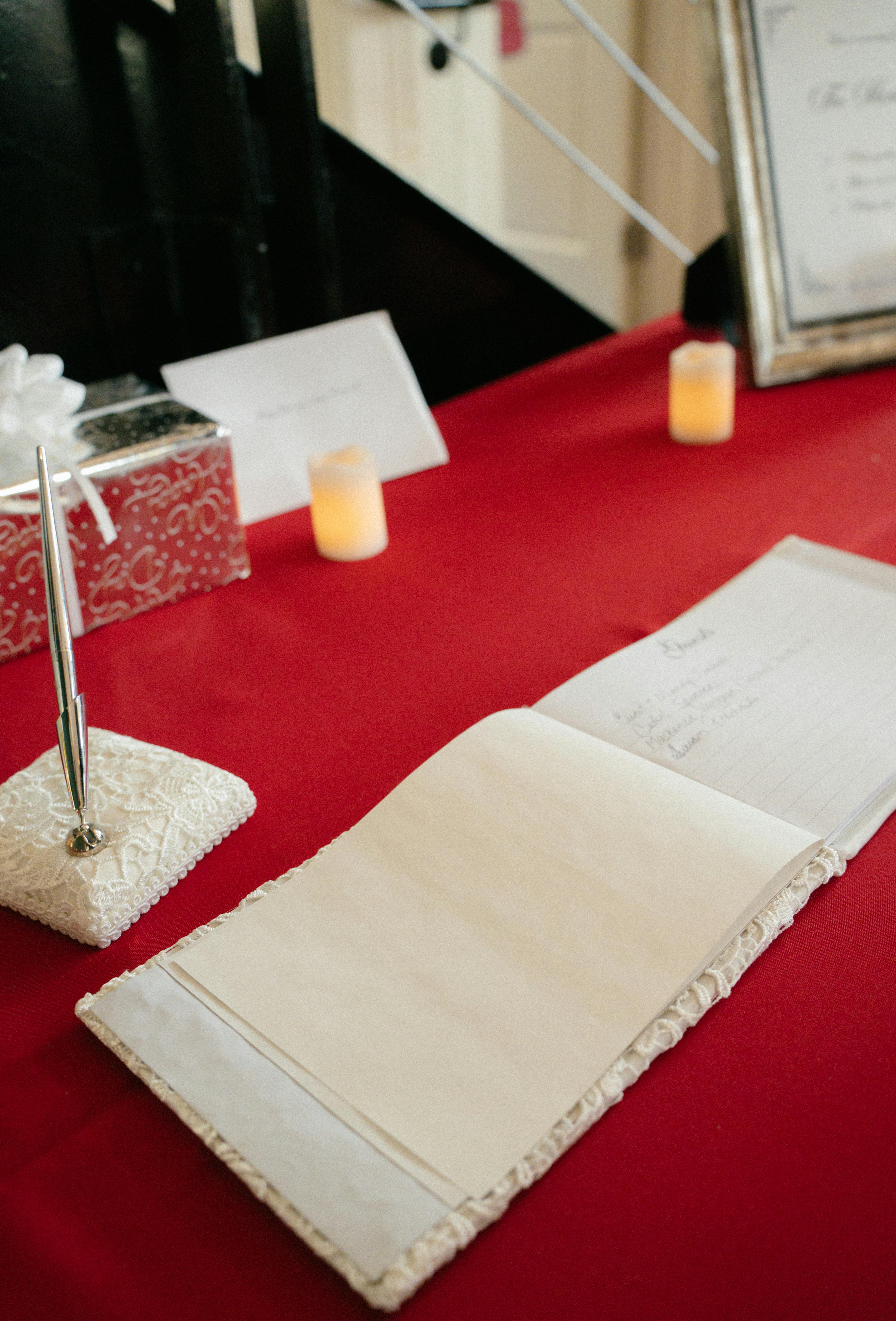 Libro de firmas de boda preparado sobre una mesa de recepcion con boligrafo y decoracion