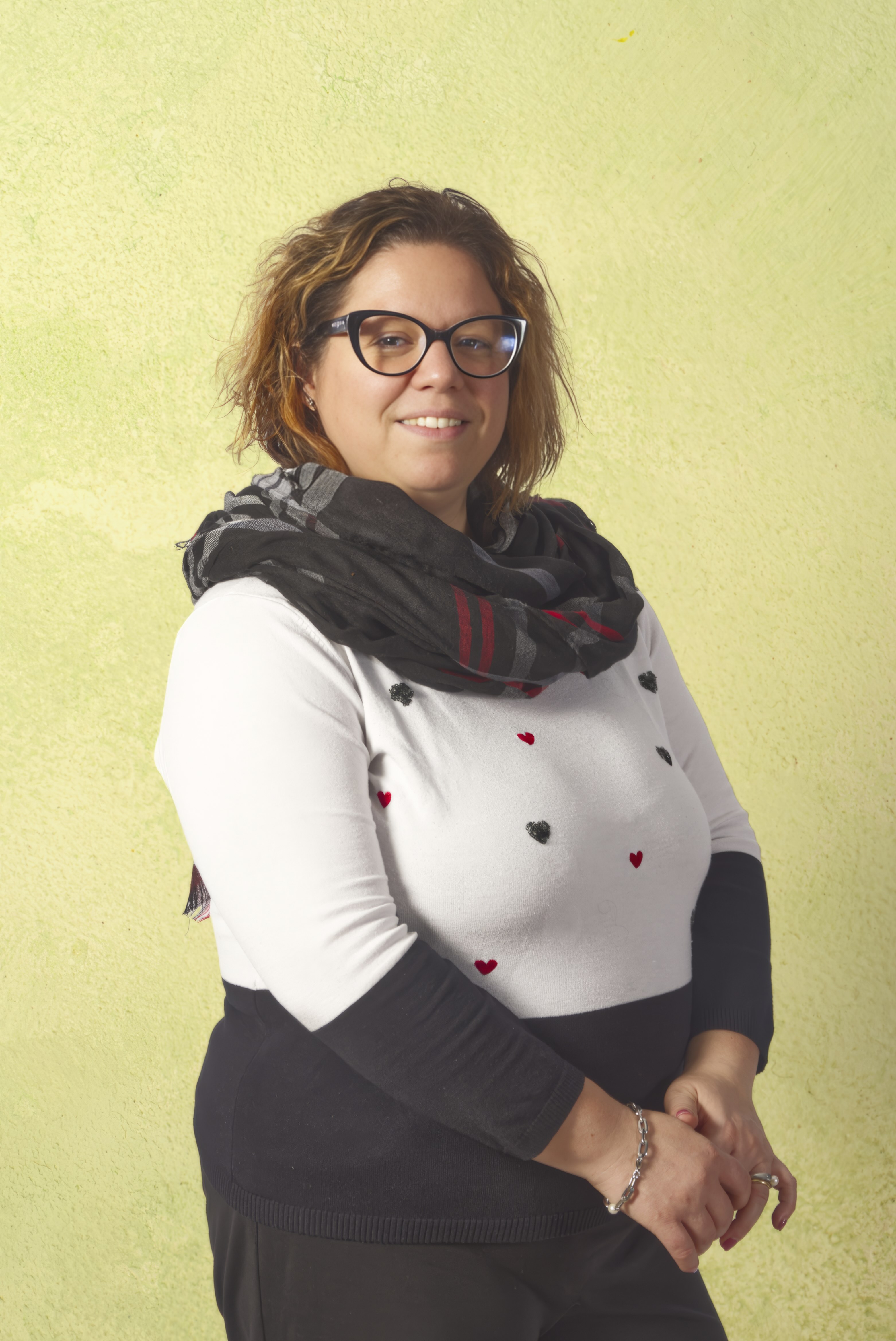 Donna sorridente con occhiali e sciarpa.