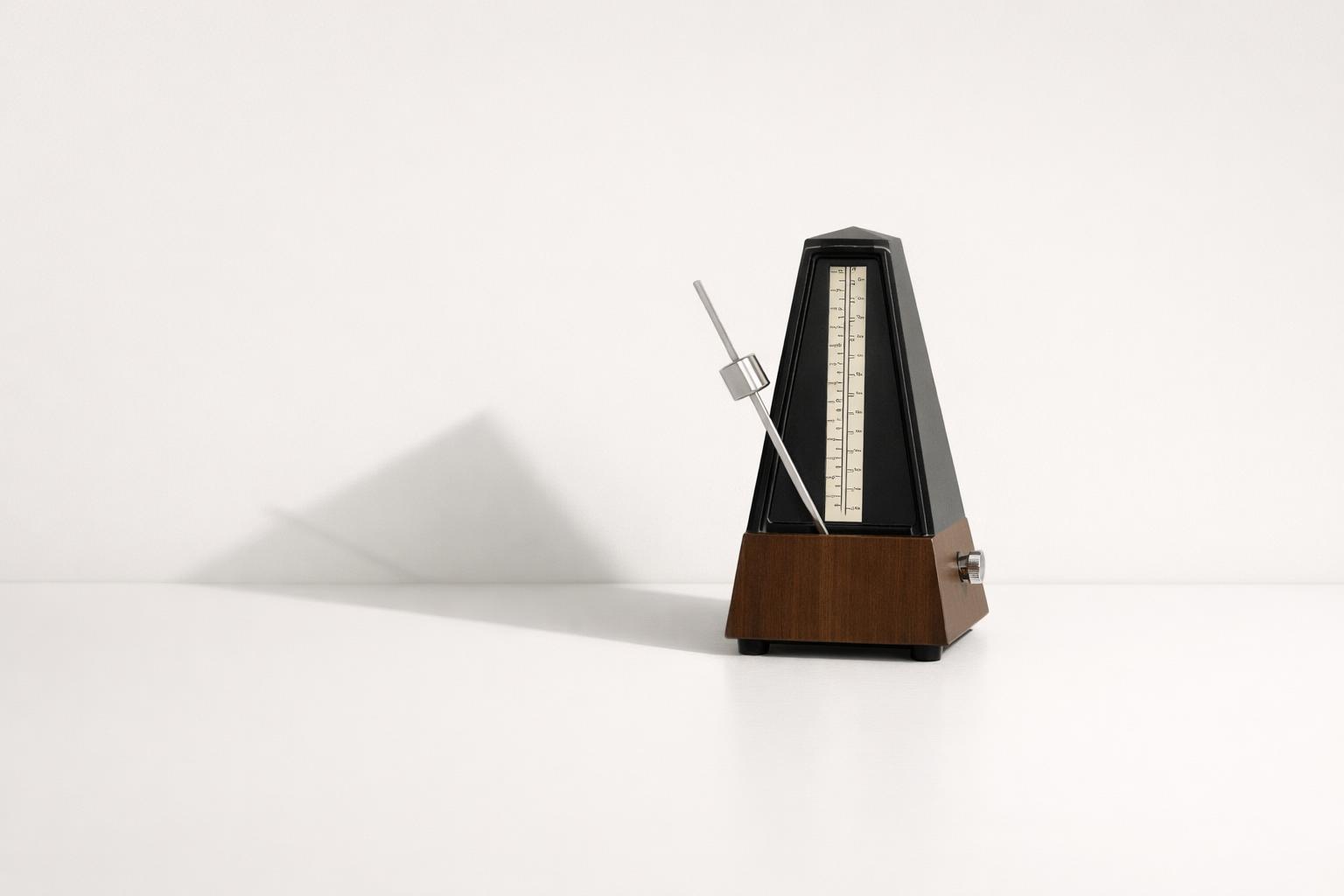 Balanced metronome symbolizing focus, consistency, and follow-through on a clean desk