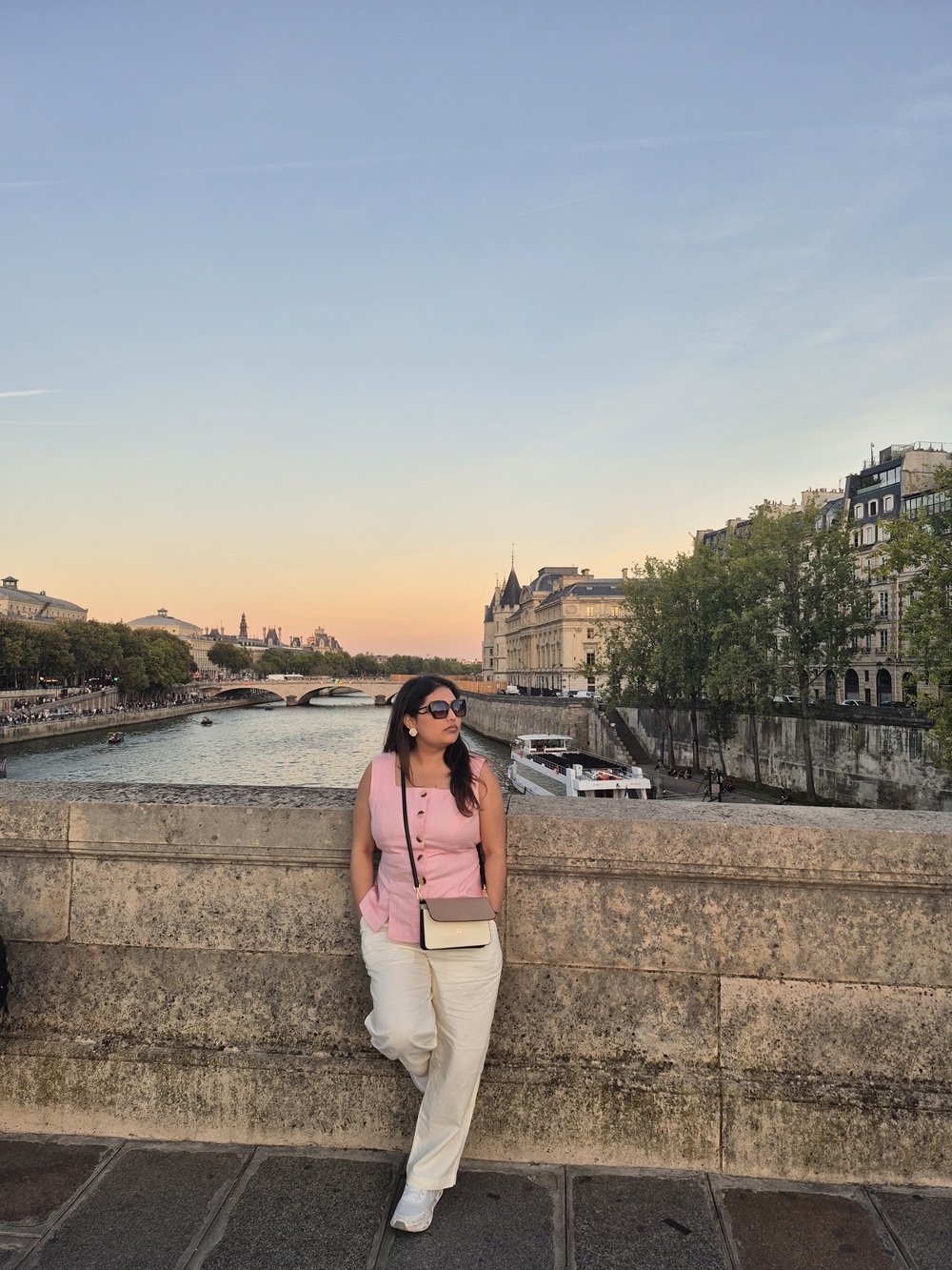Woman standing beside the River Seine in Paris at sunset