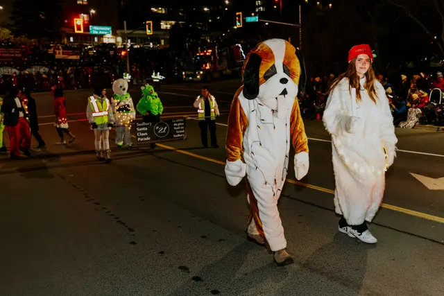 A person in a St. Bernard dog costume walks beside another in a white fur costume.