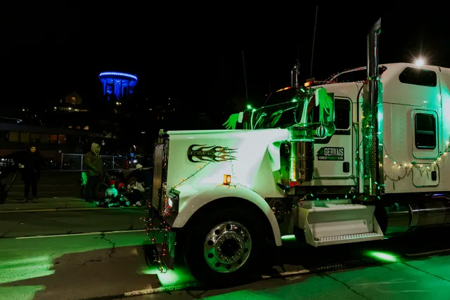 A Gervais transport truck lit in green drives the parade route.