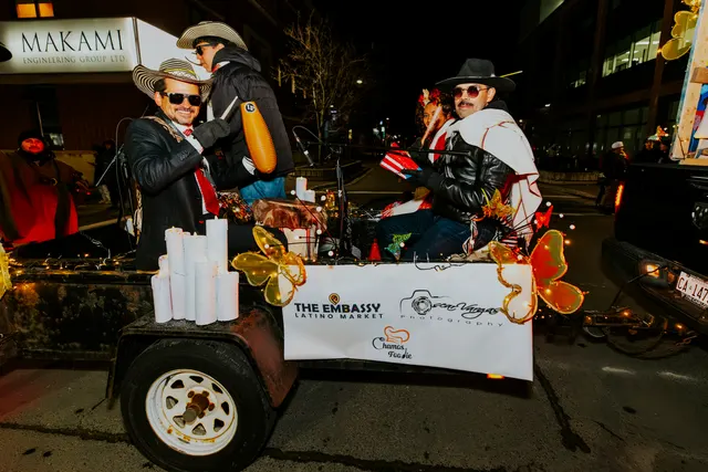 Costumed riders wave from The Embassy Latino Market float decorated with gold butterflies.