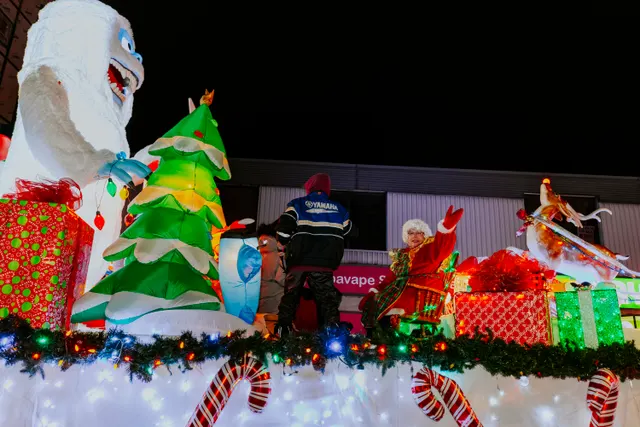 A giant white yeti figure and a Mrs. Claus mannequin decorate a float trimmed with candy canes and gifts.
