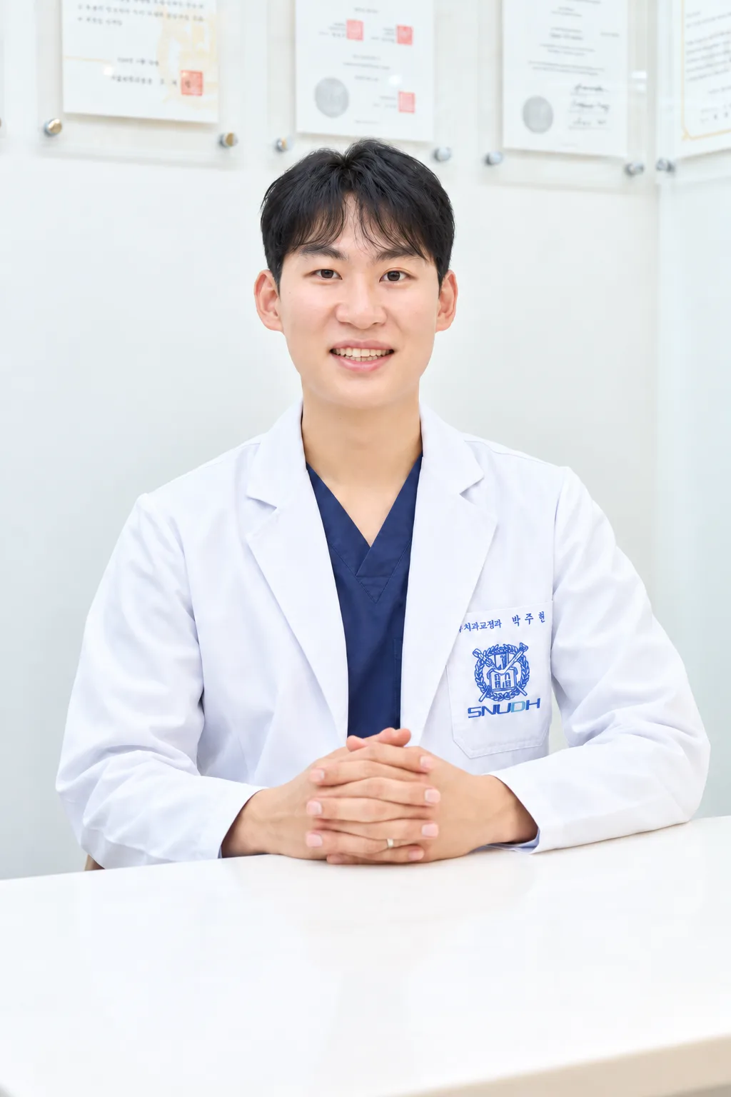밝은 진료실의 미소 짓는 치과의사