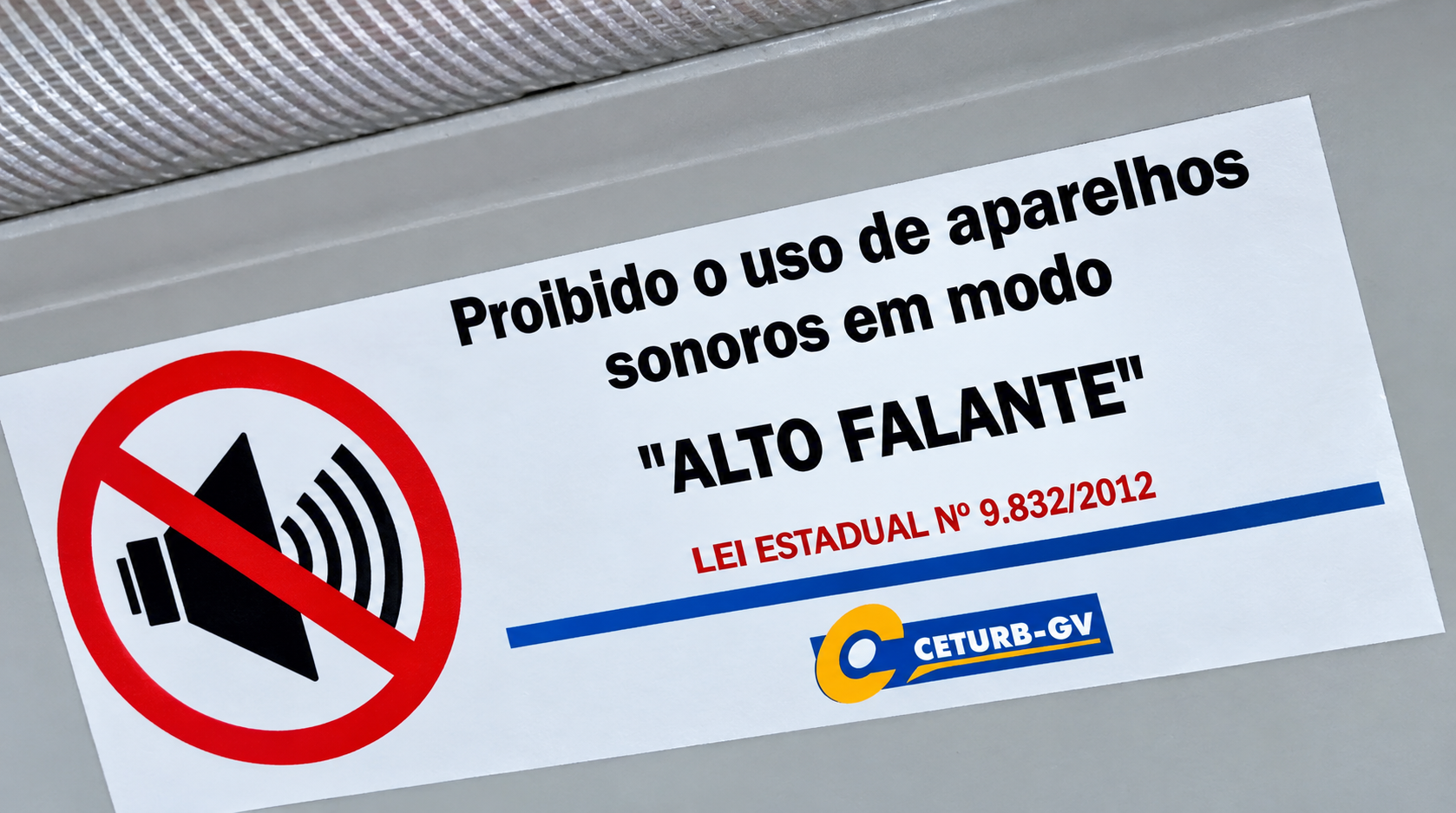 Cartaz exibindo Lei que proíbe o uso de aparelhos sonoros em modo "alto falante" em transportes coletivos.