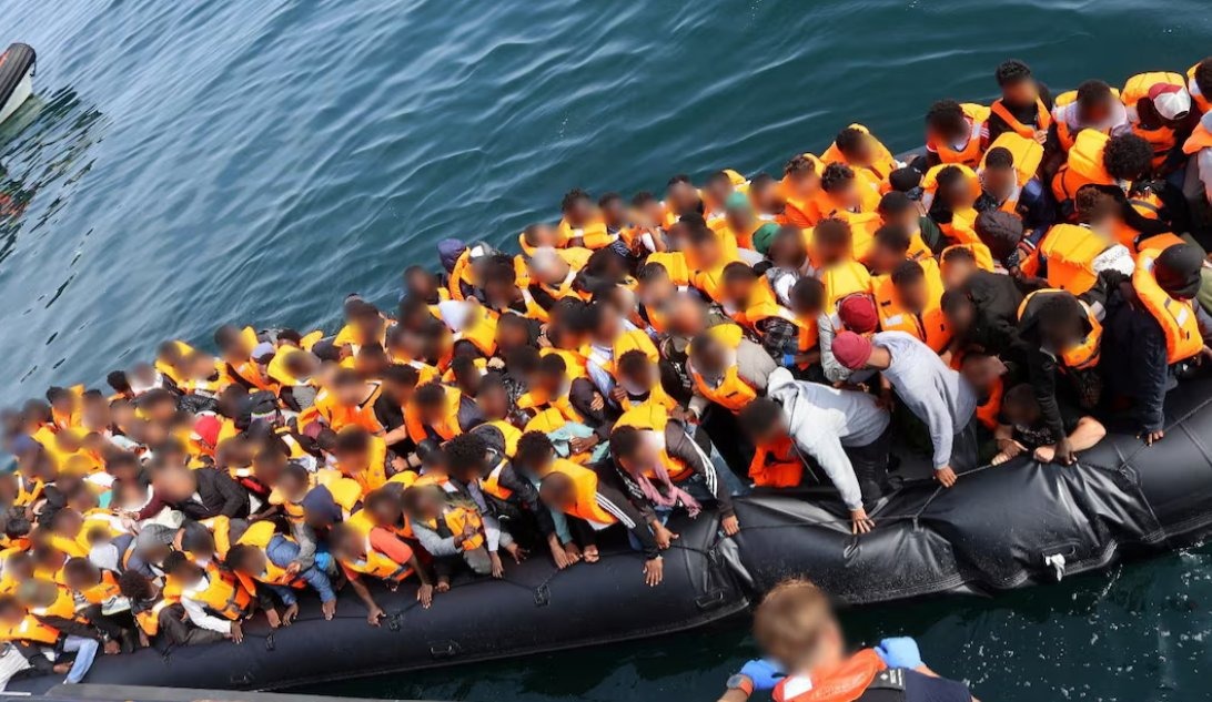 Migrants packed onto an inflatable dinghy in the English Channel, as total rubber-dinghy crossings this year have now exceeded 20,000.