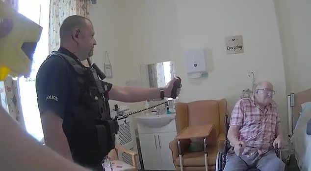 A Sussex Police officer points a Taser at Donald Burgess, who died in hospital three weeks after the care-home confrontation that PC Stephen Smith and PC Comotto now face a disciplinary panel over.