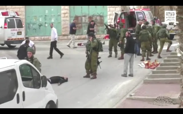 Israeli soldiers and civilians at the Hebron street scene where Elor Azaria shot dead an immobilised, unarmed Palestinian — a conviction whose last legal consequence Isaac Herzog has now expunged.