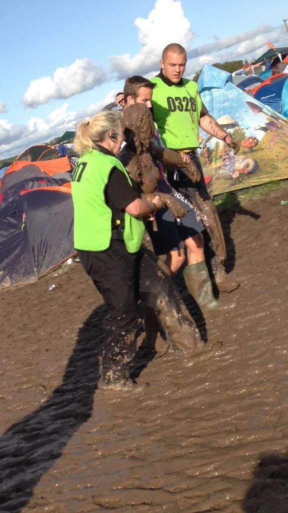 A festival-goer is rescued from the mud at Reading, where heavy, thundery showers are forecast to push into the site by Sunday evening.