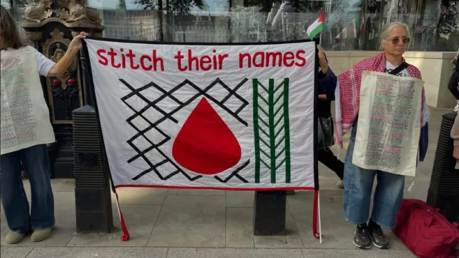 Supporters of the Stitch Their Names Together exhibition on a pavement, as the Leeds Jewish Representative Council warned the full tapestry — only 4,000 of its more than 50,000 stitched names examined so far — could…