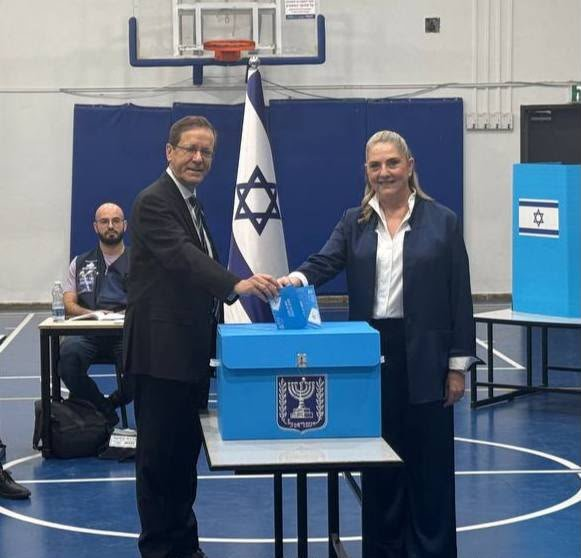 Isaac Herzog pictured with a woman, as Benjamin Netanyahu faces corruption charges while running slightly behind rival Gadi Eisenkot ahead of Israel's first election since the October 7 massacre.