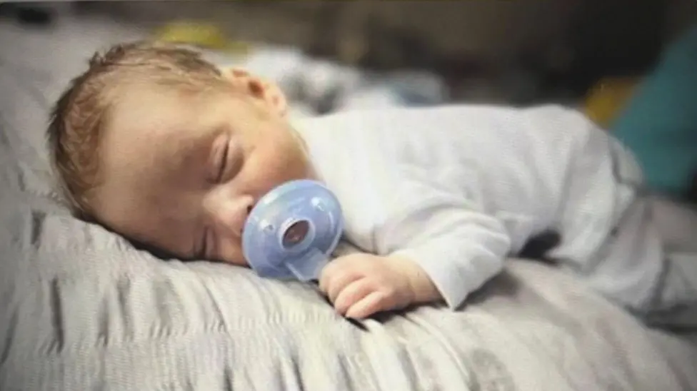 Hunter Hodges, the infant whose injuries also included wounds consistent with violent shaking on an earlier, separate occasion, in a family photograph.