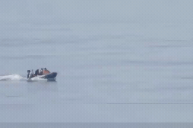 A small dinghy carrying migrants crosses the English Channel toward a Kent beach — a vessel like it reached Dover just one mile offshore before a passenger had to dial 999, exposing a gap in the joint French-UK…