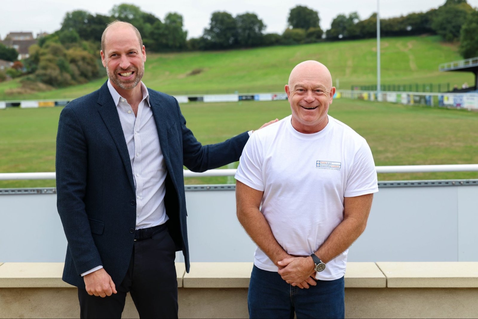 Prince William taps Ross Kemp on the shoulder to mimic the Traitors' murder mechanic — a nod to what a royal biographer says is William and Kate's favourite shared viewing.