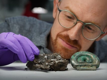 A man in purple gloves examines pieces from the Blyth Hoard, which Dr Matthew Knight of National Museums Scotland described as a "special find in its own right.