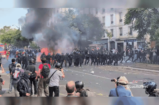 Riot police advance through smoke near Place de la Nation in Paris as clashes broke out on the margins of the mass demonstrations.