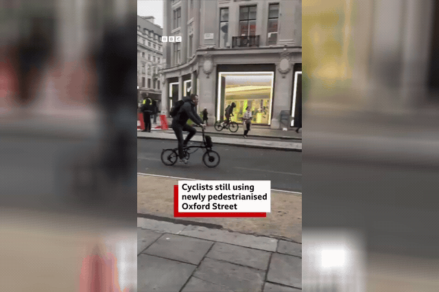 Cyclists continuing to ride along the newly pedestrianised section of Oxford Street, where one rider obeyed an enforcement officer's order to dismount, then resumed pedalling the moment the officer turned away.