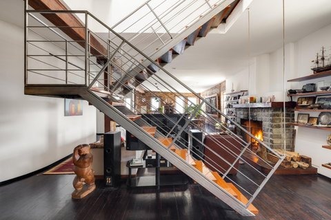 The steel staircase and open living area of the Greenwich Street penthouse, which sits within the West Village Historic District with protected skyline views over Hudson River Park.