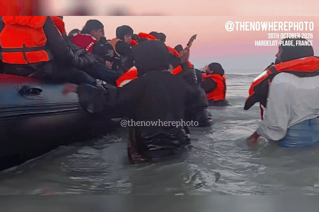 A migrant pulls a large knife on a smuggler boat bound for Britain, in a picture posted on X by The Nowhere Photographer, as a British man at the scene was heard alerting the coastguard that the knifeman was armed.
