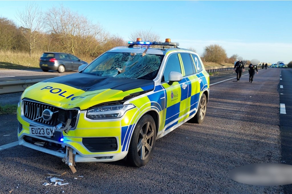 The damaged Essex Police patrol car on the A120, its windscreen struck when an unsecured load fell from Glenn Lillie's Audi and crossed the central barrier, showering both officers inside with shattered glass.