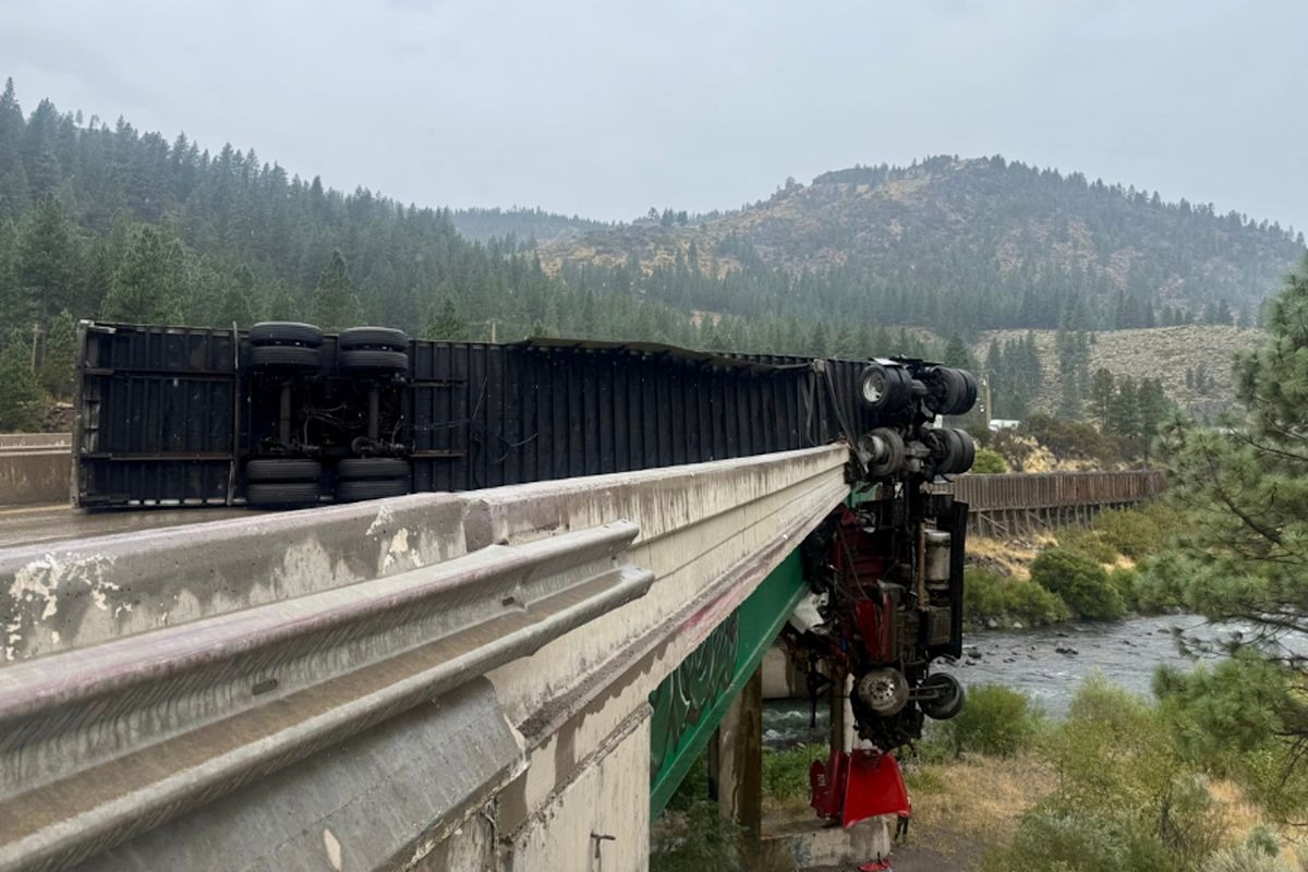 Rain and speed are believed to have caused the truck to strike the barrier and flip, ejecting the driver onto an embankment below.