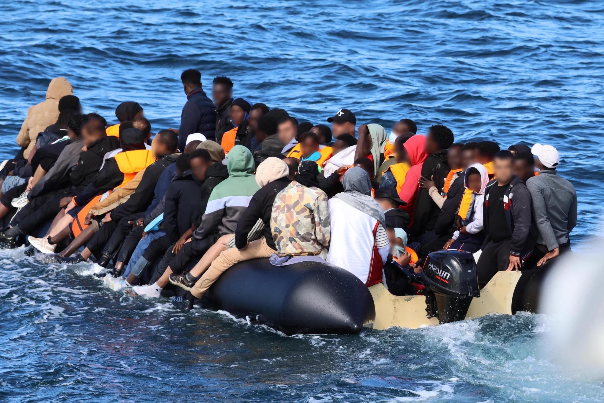 An overcrowded inflatable dinghy on the English Channel, of the kind used by migrants crossing from France — Eritreans made up 18% of all small boat arrivals in the year to June, the single largest nationality.