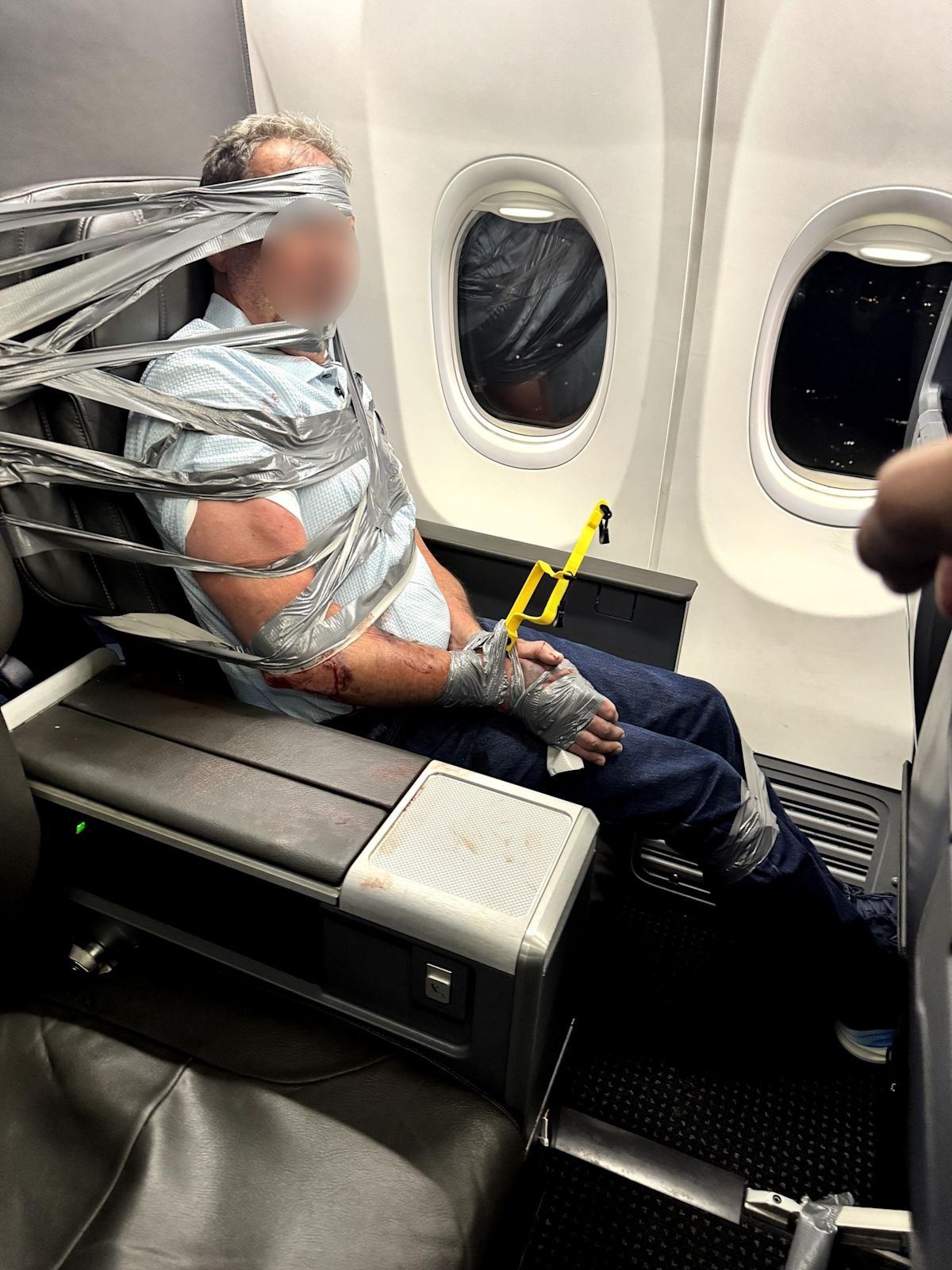 Layne Lundeen restrained with duct tape and zip ties aboard the American Airlines flight, after two screwdriver cocktails preceded the mid-air outburst that forced an emergency landing in Baltimore.