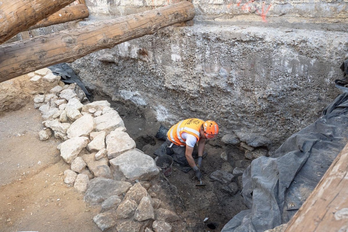 A 20-metre charred wall of stone and wood unearthed beneath the Hôtel-Dieu Hospital courtyard, near Notre-Dame, where excavations begun in February 2026 revealed findings that could finally settle a long-running debate…