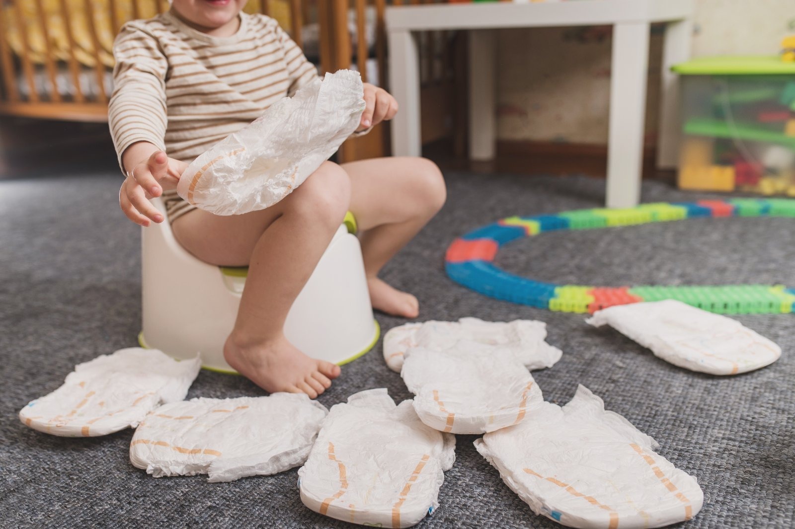 A toddler with a nappy amid potty-training equipment. Nappy-changing duties in schools are costing teachers the equivalent of a full day's teaching time each week.