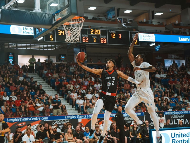 Basketball player shoots the ball over an opponent.
